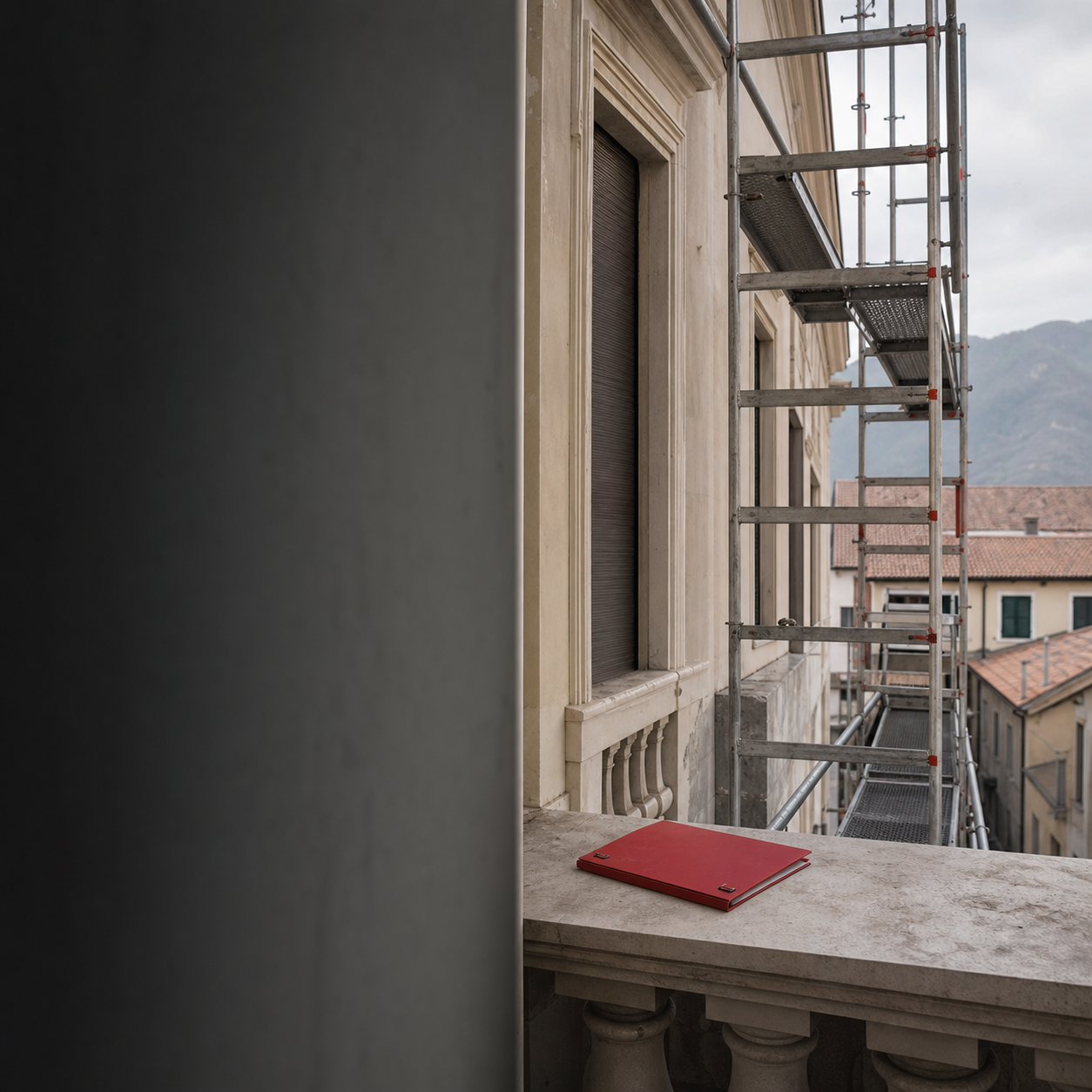 Facciata di un condominio del Nord-Est con ponteggio ordinato e cartella di progetto rossa su una balaustra.